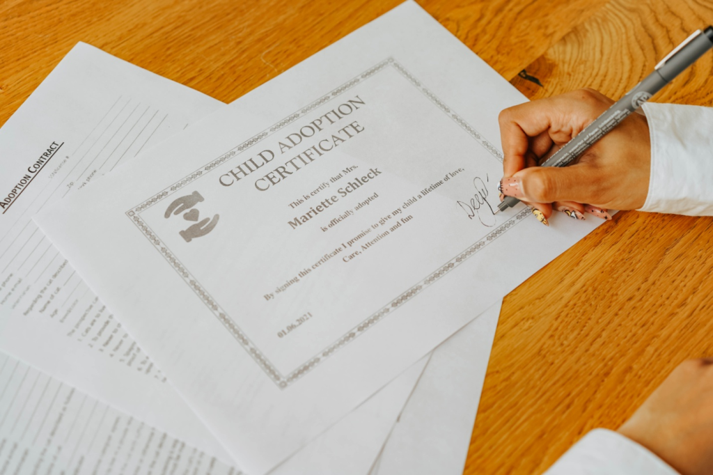 A person signing a child adoption certificate 