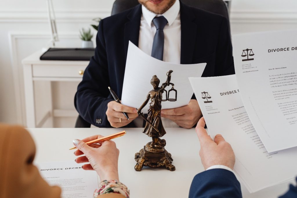 A couple signing divorce papers with a family court lawyer