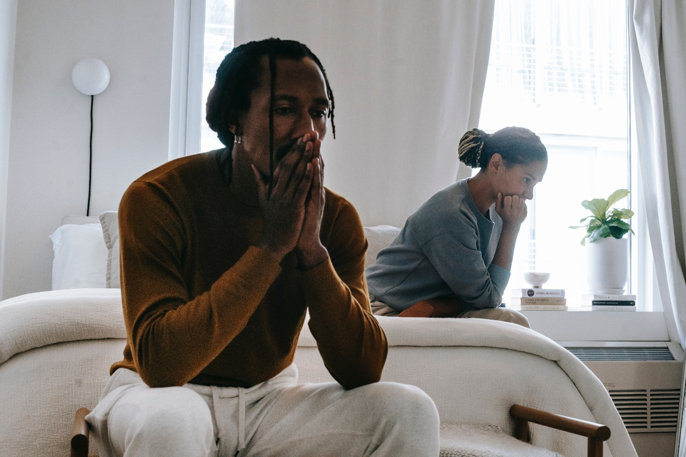 A couple sitting on bed after an argument 