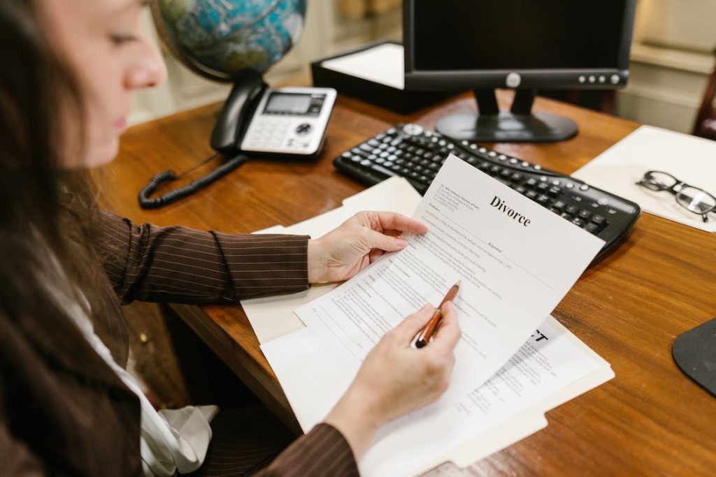 A professional woman reviewing a divorce document at her desk.