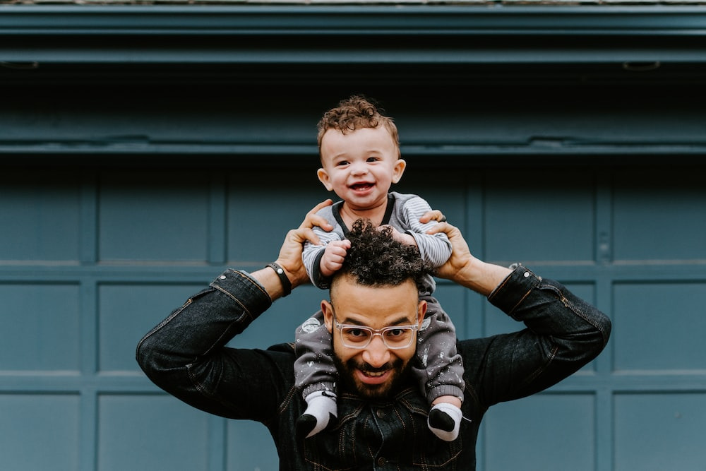  Joyful father lifting his smiling child above his head.