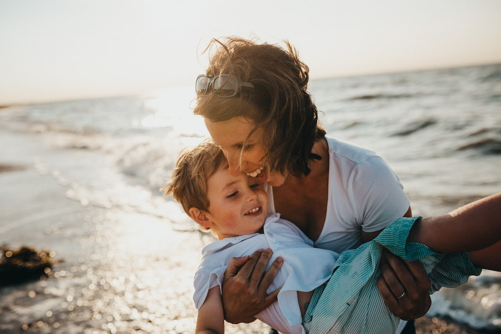  Mother embracing her child on a beach