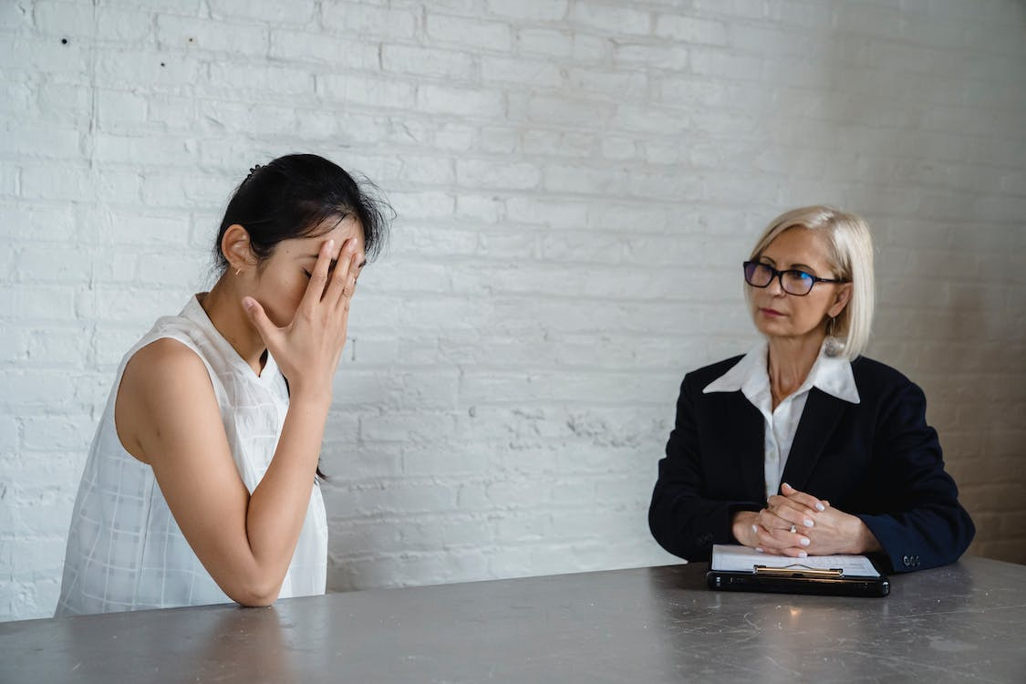 A woman expressing distress during a consultation with her lawyer.