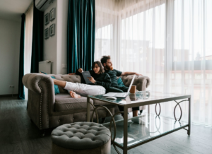 Couple relaxing on a couch together with a laptop and tablet