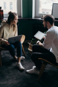 Couple discussing something while holding a laptop and tablet