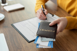 Person holding a passport and boarding pass while filling out a form