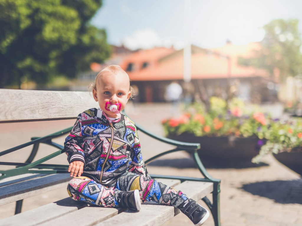 A baby sitting on a bench