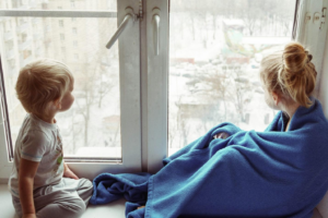 Two kids looking out a window