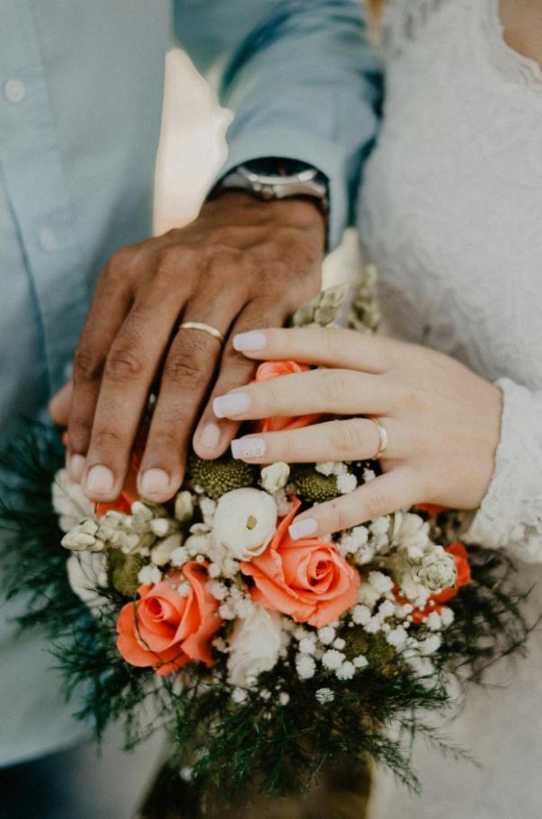 A newly married couple holding a bouquet